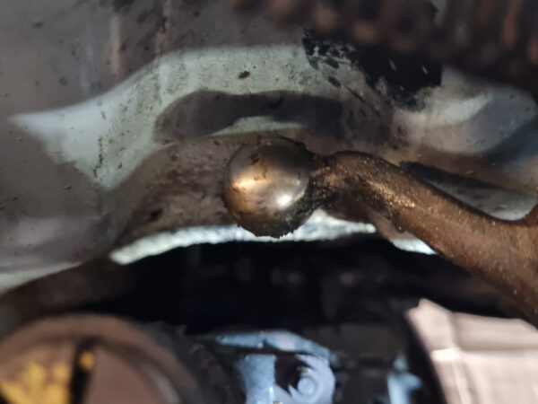 Schaltgestängehalterung mit Rückholfeder und Umlenkhebel im Motorraum der Lancia Fulvia Berlina, aufgenommen als Einbau- und Funktionsreferenz.