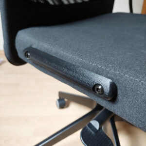 Nahaufnahme der schwarzen Armlehnen-Abdeckung mit Schrauben und Abdeckkappen am IKEA MARKUS Bürostuhl