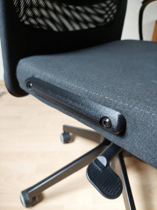 Nahaufnahme der schwarzen Armlehnen-Abdeckung mit Schrauben und Abdeckkappen am IKEA MARKUS Bürostuhl