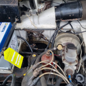 Nahaufnahme der Schaltgestängehalterung im Motorraum einer Lancia Fulvia Berlina mit eingesetzter heller Lagerbuchse an der Gestänge-Umlenkung.