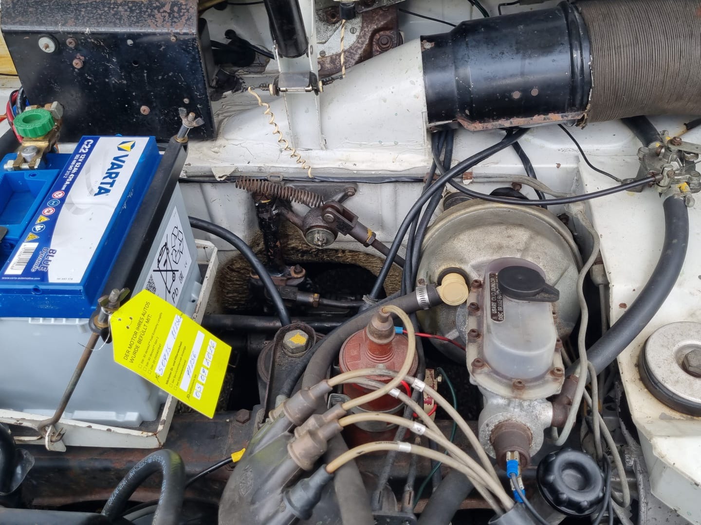 Nahaufnahme der Schaltgestängehalterung im Motorraum einer Lancia Fulvia Berlina mit eingesetzter heller Lagerbuchse an der Gestänge-Umlenkung.