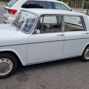 Seitenansicht einer hellen Lancia Fulvia Berlina als Fahrzeugreferenz für die Lagerbuchsen der Lenkradschaltung.
